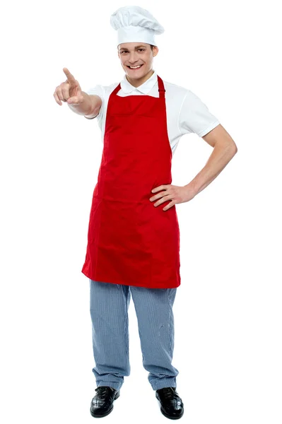 Male chef in uniform pointing away and smiling — Stock Photo, Image