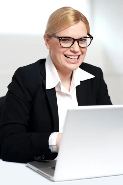 Smiling young female executive at work desk — Stock Photo, Image