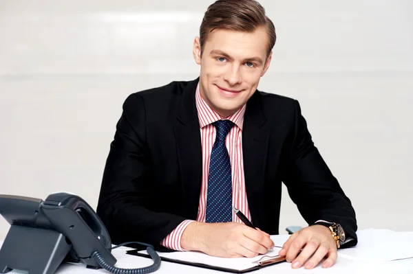 Handsome young man making notes — Stock Photo, Image