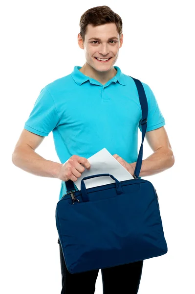 Cara tirando papel de sua bolsa de laptop — Fotografia de Stock