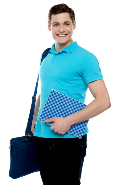 Smiling guy holding notepad and laptop bag — Stock Photo, Image