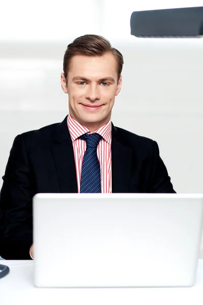 Ελκυστική χαμογελαστός άνθρωπος λειτουργεί ένα laptop — Φωτογραφία Αρχείου