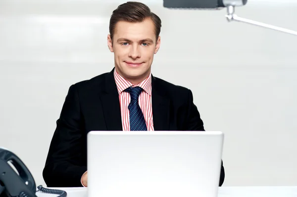 Schöner junger Geschäftsmann mit Laptop — Stockfoto