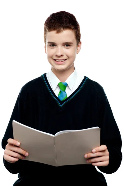 Charming schoolboy holding workbook — Stock Photo, Image