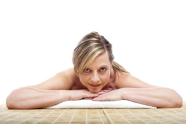 Matured naked woman lying on mattress — Stock Photo, Image