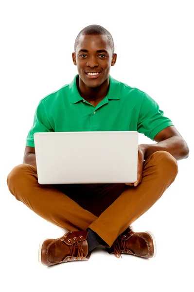 Koele kerel zittend op de vloer met behulp van laptop — Stockfoto