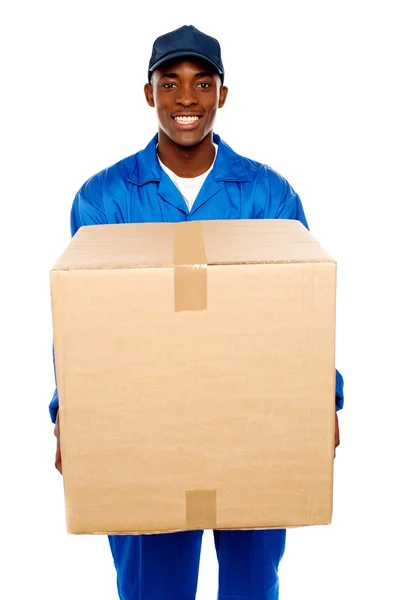 Repartidor sosteniendo gran paquete y sonriendo — Foto de Stock