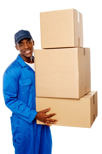 Entrega jovem cara segurando pilha de caixas de parcelas — Fotografia de Stock