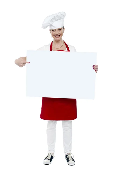 Cozinheiro experiente indicando no banner branco — Fotografia de Stock