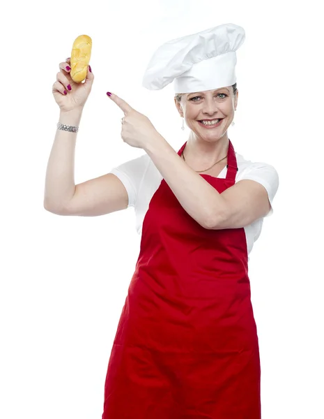 经验丰富的女厨师，指着面包 — 图库照片