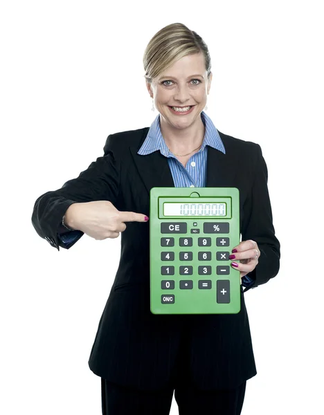 Mujer apuntando a la calculadora grande — Foto de Stock
