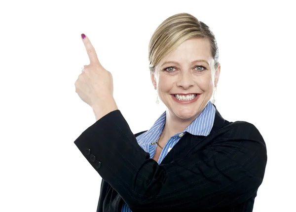Smiling corporate woman pointing upwards — Stock Photo, Image