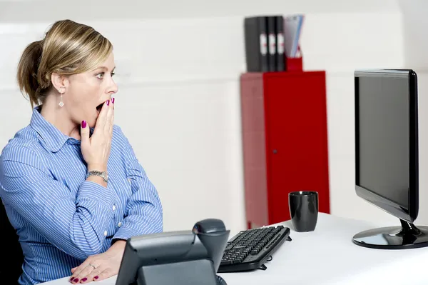 Shocked businesswoman looking at annual reports — Stock Photo, Image