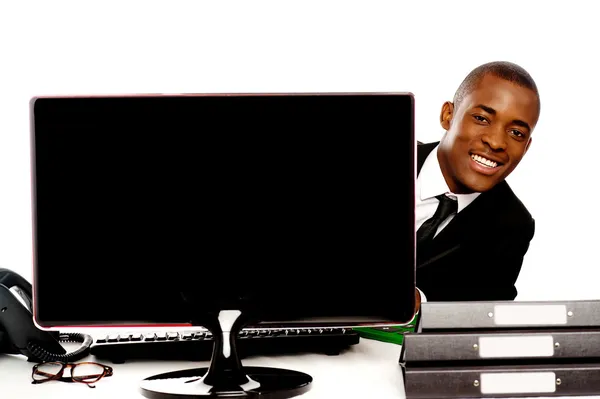 Businessman peeping from behind lcd monitor — Stock Photo, Image