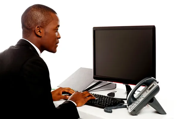 Male executive typing and looking at lcd screen — Stock Photo, Image