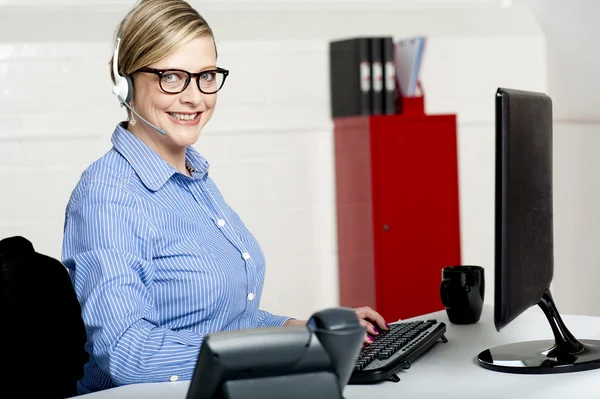 Senior woman sitting in front of computer — Stock Photo, Image