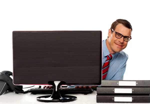 Muž vykukující zpod obrazovku počítače — Stock fotografie