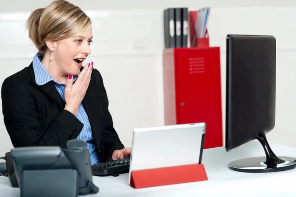 Surprised female secretary looking at lcd screen — Stock Photo, Image