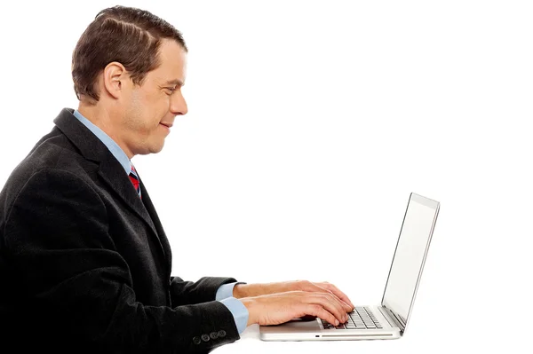 Vista lateral de la escritura masculina corporativa en el ordenador portátil — Foto de Stock