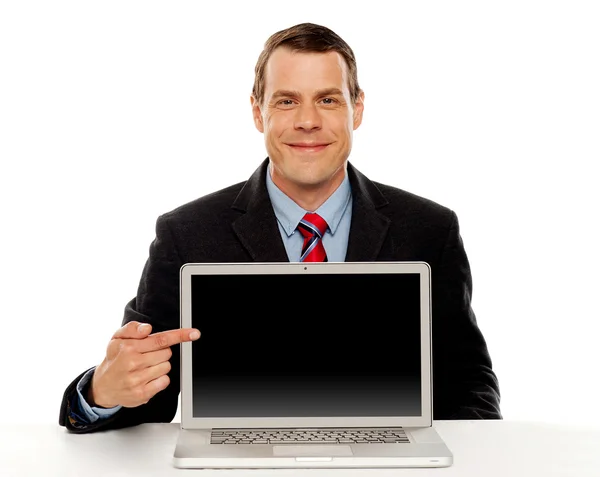 Empresario apuntando a la pantalla del ordenador portátil en blanco — Foto de Stock