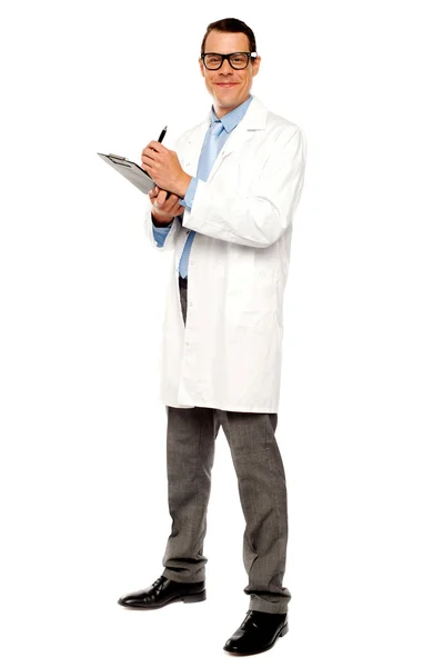 Médico joven escribiendo informe médico — Foto de Stock