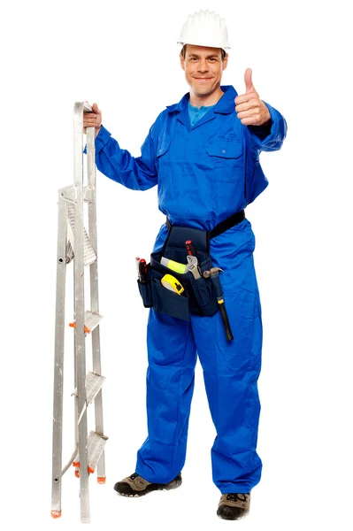 Reparador sosteniendo escalera y mostrando los pulgares hacia arriba —  Fotos de Stock