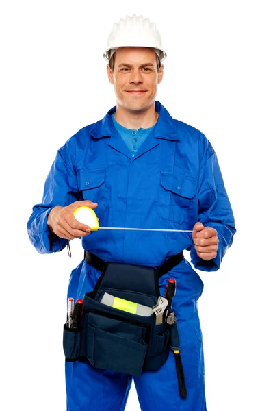 Trabalhador masculino alongamento fita métrica — Fotografia de Stock
