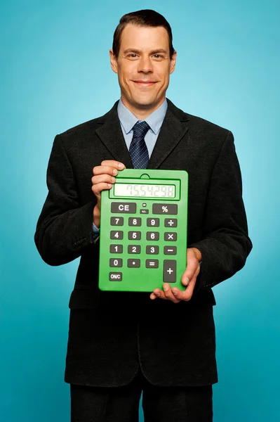 Chico corporativo mostrando gran calculadora verde — Foto de Stock