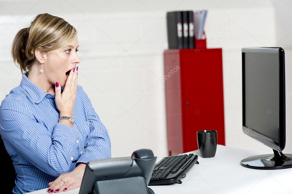 Shocked businesswoman looking at annual reports