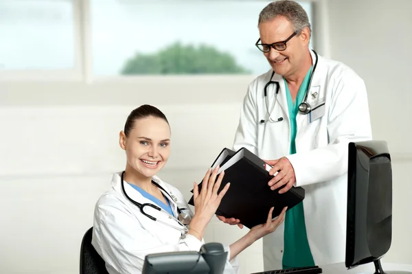Male doctor handing over files to female doctor — Stock Photo, Image