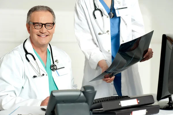 Assistentin übergibt Röntgenbericht an männlichen Arzt — Stockfoto