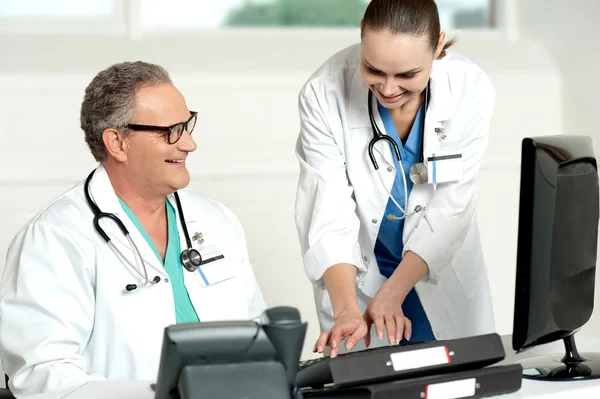 Uśmiechający się zespół medyczny, pracując na komputerze — Zdjęcie stockowe