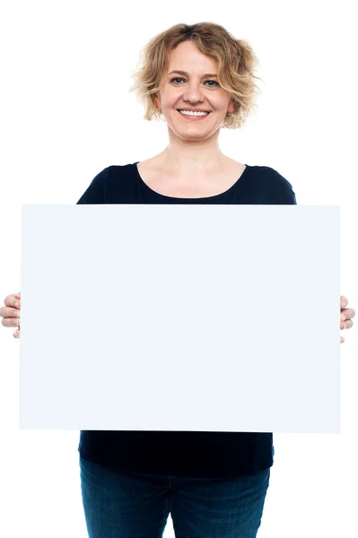 Signora casual che mostra cartellone bianco vuoto — Foto Stock