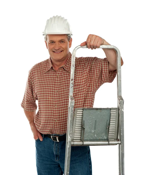 Lächelnder älterer Arbeiter posiert mit Leiter — Stockfoto