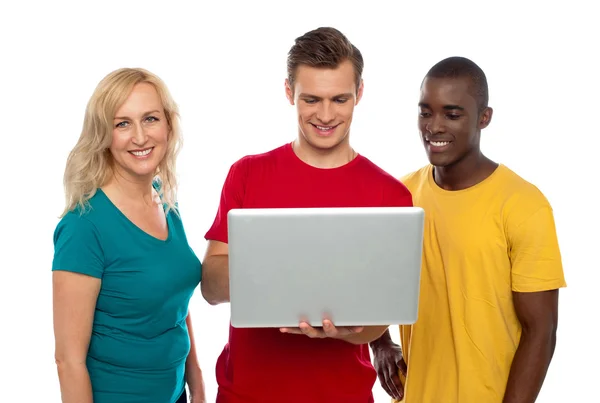 Cheerful group of friends working on laptop — Stock Photo, Image