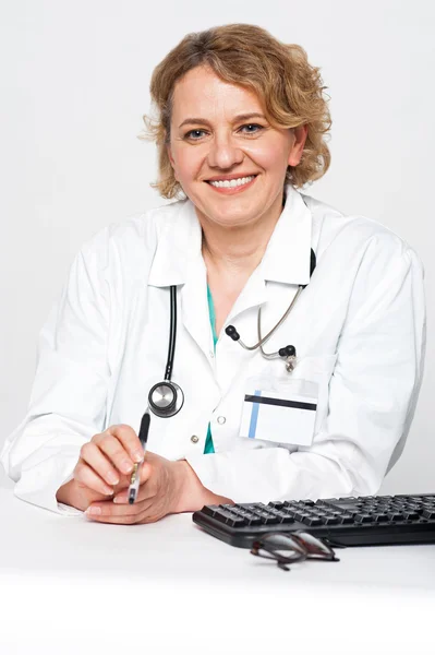 Säker kvinnliga kirurgen sitter sysslolös, håller pennan — Stockfoto