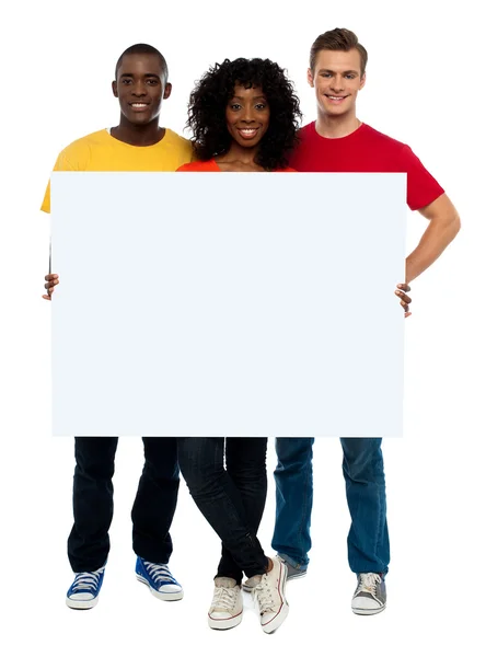 Adolescentes sorridentes apresentando cartaz em branco — Fotografia de Stock