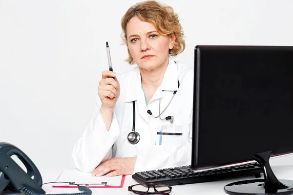 Ernstige leeftijd arts poseren met pen in de hand — Stockfoto