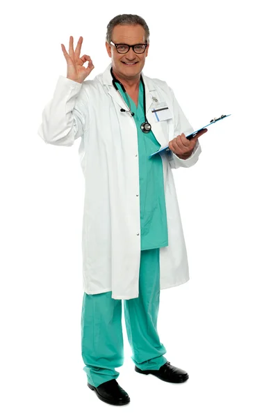 Männlicher Arzt mit hervorragender Geste, Klemmbrett haltend — Stockfoto