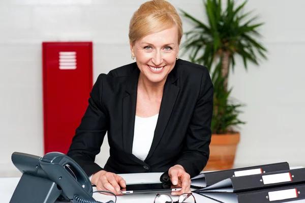 Sonriente dama corporativa sosteniendo la tableta inalámbrica —  Fotos de Stock