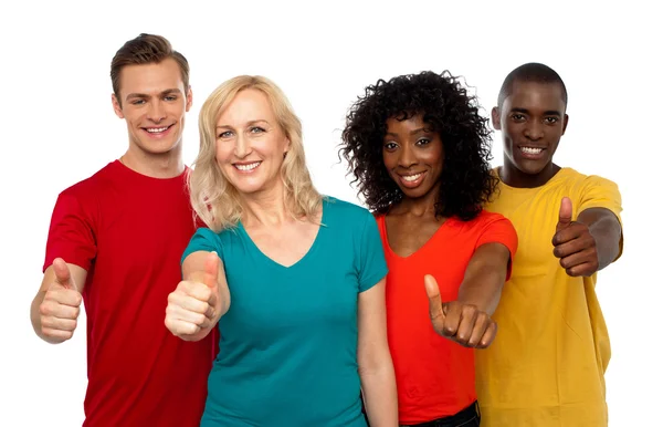 Smiling team of young showing thumbs up — Stock Photo, Image
