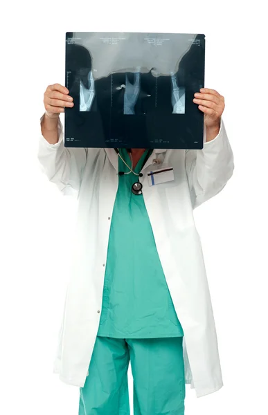 男性の外科医がレントゲン検査報告書と彼の顔を隠す — ストック写真