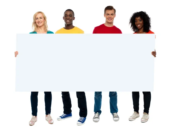 Confident young group showing blank poster — Stock Photo, Image