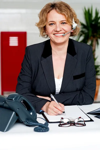 Female executive assisting customers on call — Stock Photo, Image