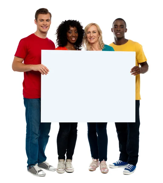 Team av unga håller whiteboard — Stockfoto