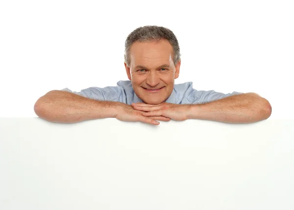 Smiling man behind blank white banner ad — Stock Photo, Image