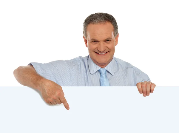 Promotor masculino casual apuntando a la cartelera en blanco —  Fotos de Stock