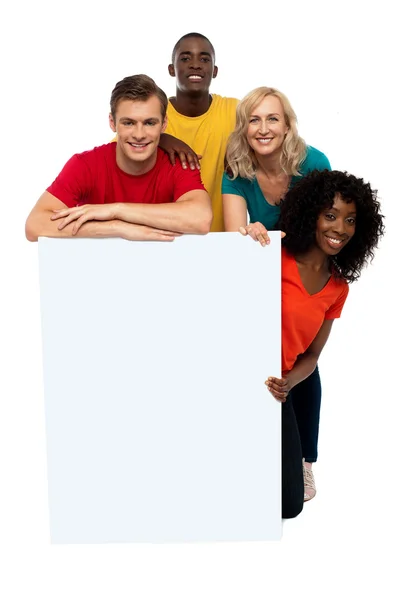 Group of teenagers displaying white banner — Stock Photo, Image