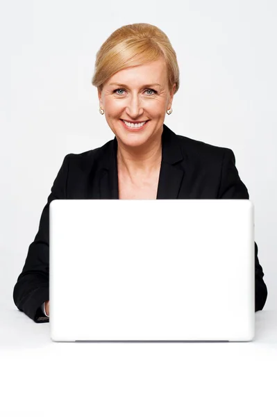 Senhora corporativa envelhecida trabalhando em um laptop — Fotografia de Stock