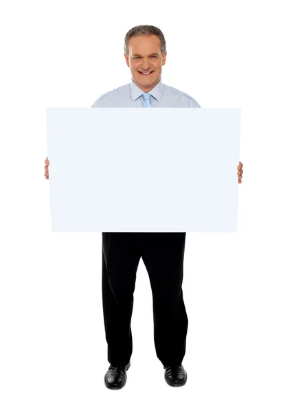 Hombre de negocios seguro sosteniendo la cartelera en blanco — Foto de Stock